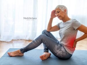 Femme en tenue de sport sur tapis de yoga avec 10 exercices pour les douleurs lombaires