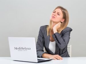 donna con dolore al collo alla scrivania