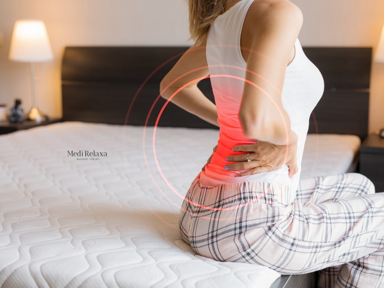 Frau im Bett mit Rückenschmerzen nach dem Schlafen