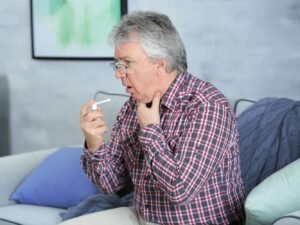 hombre con dolor de garganta persistente y fatiga