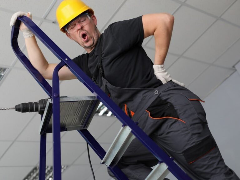 werkman op ladder die een acute lumbago krijgt