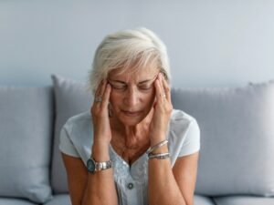 mujer en el asiento con dolor de cabeza