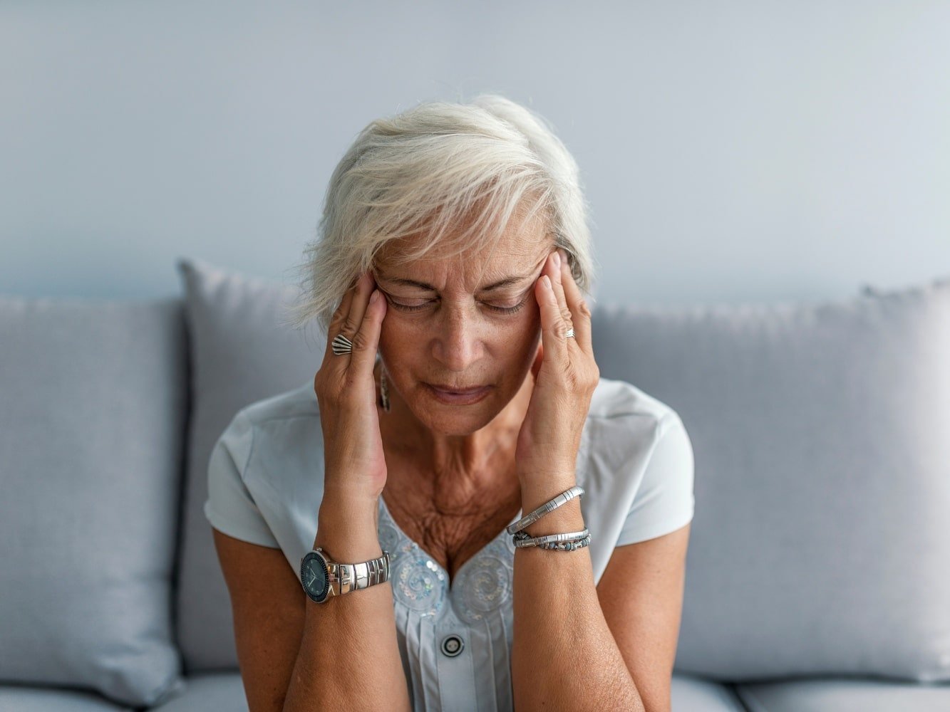 vrouw in zetel met hoofdpijn