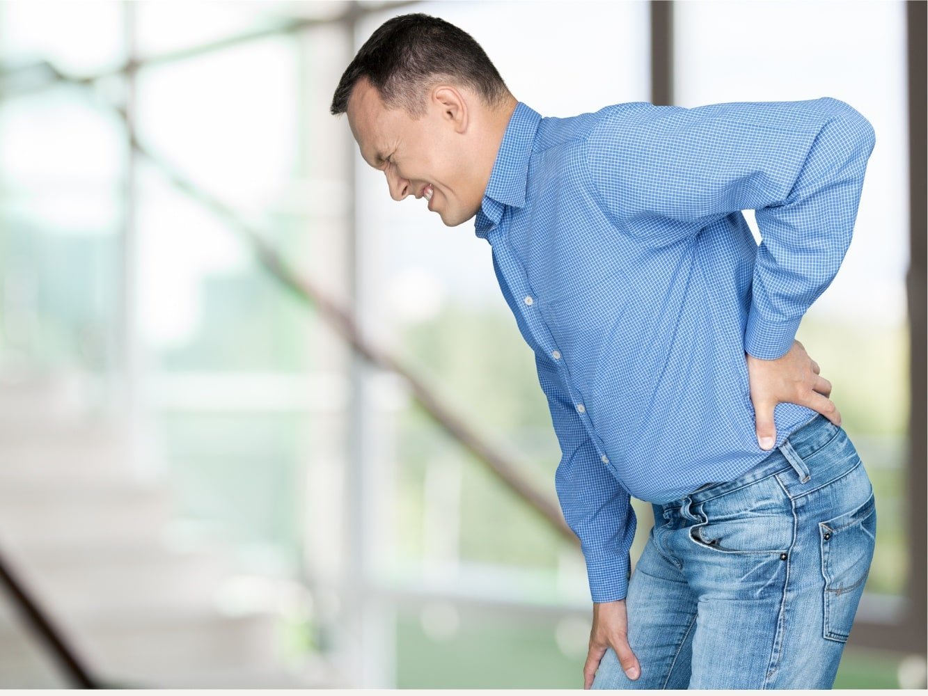 hombre con lumbago se estira de la espalda