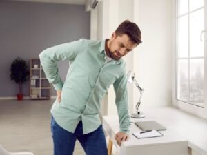 man in groene shirt die lumbago oefeningen doet