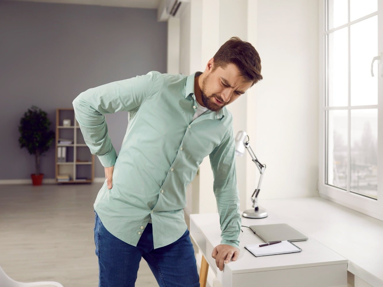 man in groene shirt die lumbago oefeningen doet