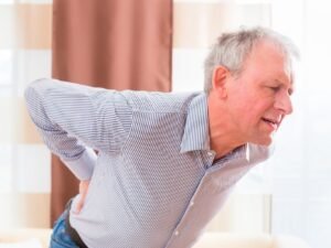 anciano con dolor en la zona lumbar y las caderas