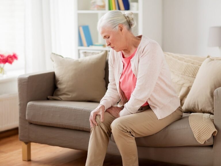 donna seduta con dolore muscolare alla gamba