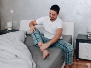 hombre en pijama con dolor muscular en todo el cuerpo y cansado