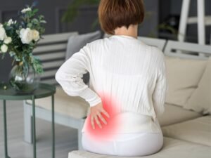 donna seduta con dolore fastidioso alla schiena donna