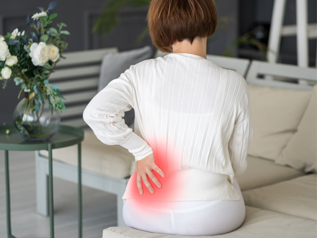 mujer sentada con dolor persistente espalda baja mujer