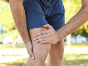 homme s'aidant de ses jambes douloureuses