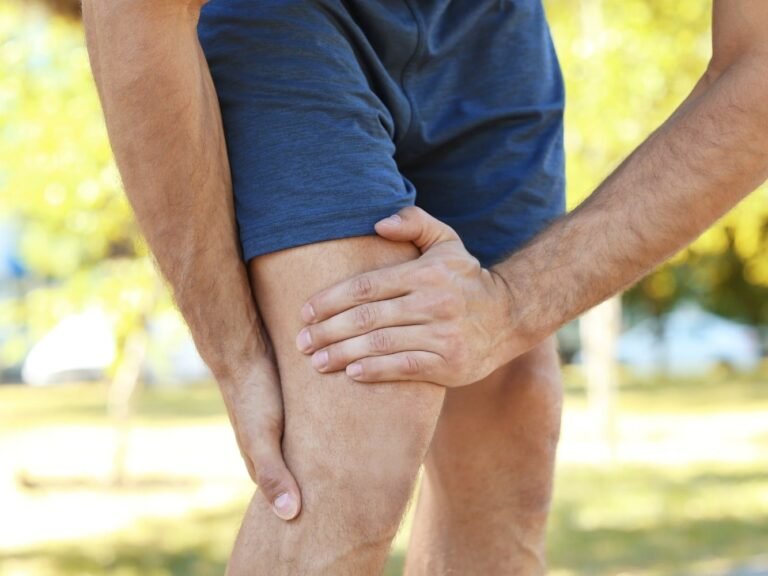 man die grijpt naar pijnlijke benen