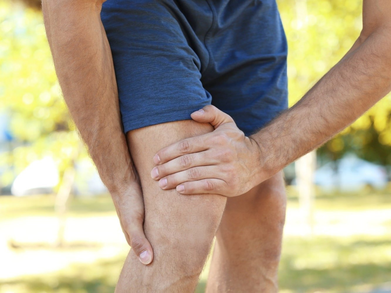 man grasping at aching legs
