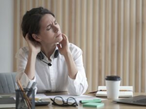 Femme au bureau souffrant de rhumatisme musculaire et de stress
