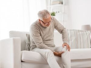 man met Spierreuma symptomen in de zetel